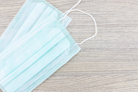 Two medical hygienic face masks on wooden background