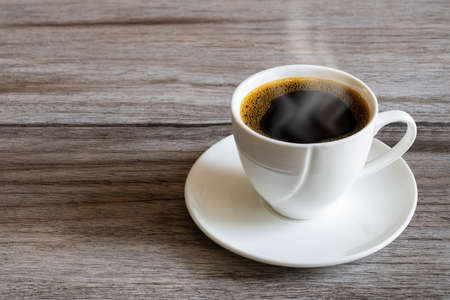 Hot white coffee cup on grunge vintage wooden tabletopの写真素材