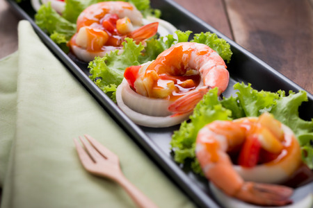 sweet and sour shrimp, prawn cocktail on long square dish and wooden backgroundの写真素材