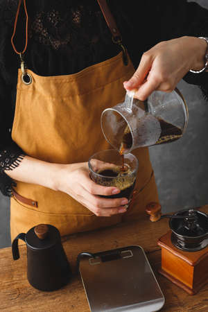 Barista making a drip coffee, pouring finished hot coffee into a cupの写真素材
