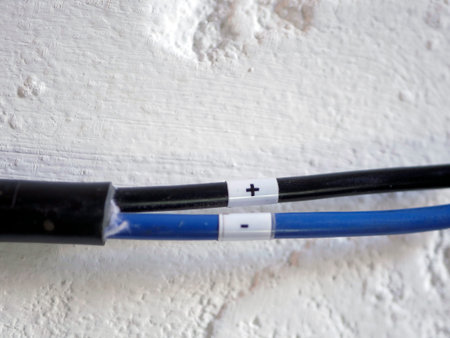 White electrical wire against a white brick wall