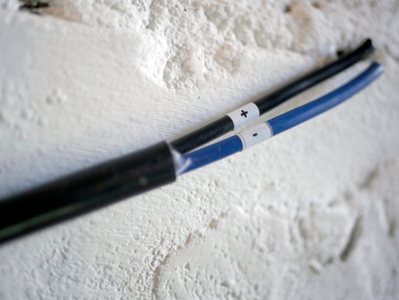 White electrical wire against a white brick wall