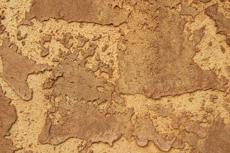 Roughly mudded stucco wall texture in rich brown.