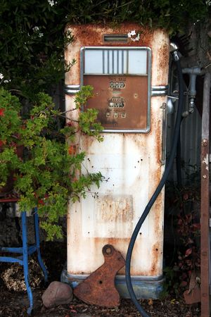 An old gas pump sitting with other relics as garden art.の写真素材