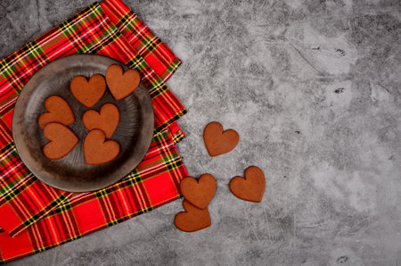 Gingerbread heart on a black clay plate and Christmas decorations .Gray concrete wall background, Gingerbread cookie and Christmas decorations. Copy space, Christmas conceptの写真素材