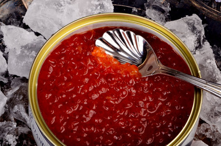 RIGA, LATVIA - december 31, 2020: Opened tin can with Red Salmon Caviar on natural ice in rustic silver plate. Red Lemberg caviar, iron can with red salmon caviarのeditorial素材