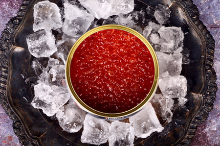 RIGA, LATVIA - december 31, 2020: Opened tin can with Red Salmon Caviar on natural ice in rustic silver plate. Red Lemberg caviar, iron can with red salmon caviarのeditorial素材