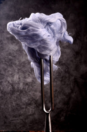 A piece of light blue fabric on a black background. Gauze and articles of gauze