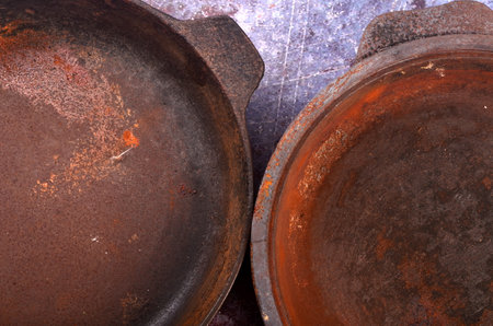 Rusty metal pans on a rustic background. Renovation of cast iron pan. Old rusty round cast iron frying pan. view from aboveの写真素材