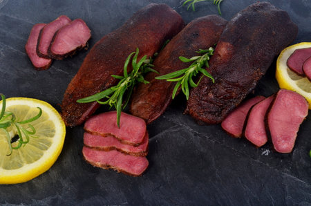 smoked pork tongue isolated on a white background and decorated with rosemary branchesの写真素材