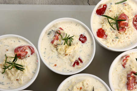 several dishes with casserole - sour cream, tomatoes and fish or other ingredients before baking. dishes with unroasted julienneの写真素材