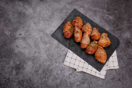 Marinated raw chicken legs on black stone plate. Uncooked marinated chickenの写真素材