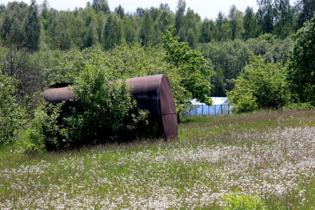 Large metal barrel for water. A metal water barrel stands in the garden.Old rusty Barrel for Irrigation at the Agricultural Fieldの写真素材