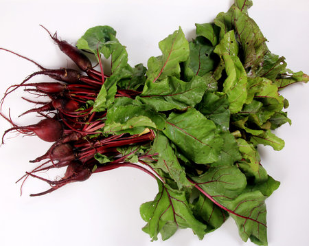 stack of young beets with leaves isolated on a white background. Beet greens bundle young fresh...