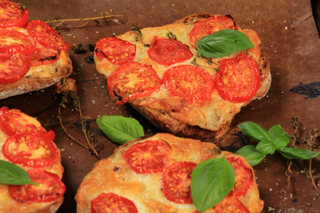 Tomato Mozzarella Toast on metal pan. Sandwich toasts with tomatoes, mozzarella and basil leaves