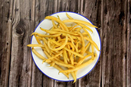 Fresh Yellow wax string beans on a dark wooden board background. Organic vegetables from farmer market, vegan food concept. Fresh Butter beanの写真素材