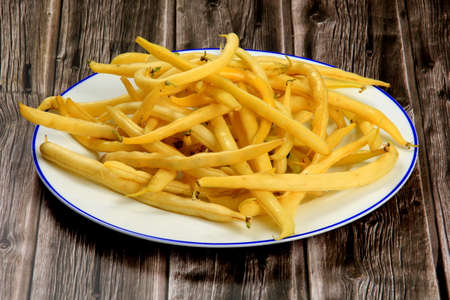 Fresh Yellow wax string beans on a dark wooden board background. Organic vegetables from farmer market, vegan food concept. Fresh Butter beanの写真素材