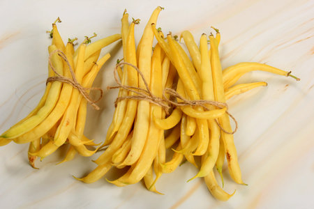 Raw Organic Yellow String Beans in a bunch on white background. Organic yellow wax bean on a table. Freshly harvested vegetables, organic food conceptの写真素材