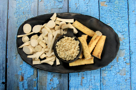 Fresh grated Horseradish roots on wooden table. The root of horseradish