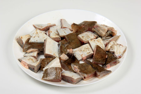Sliced Flounder fish on a white plate isolated on a white background. Fresh baltic flounder