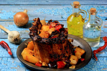 Pork Rib Crown roast with fried vegetables stuffing on a blue board backgroundの写真素材