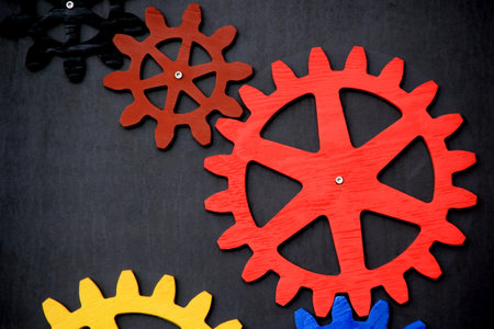 Colorful wooden gears on a black background. Space for text. A toy for children's developmentの写真素材