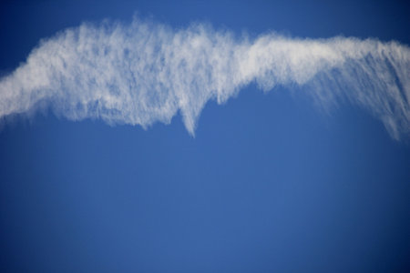 One big chemtrail over the blue sky. Massive chemtrails or contrails over blue sky backgroundの写真素材
