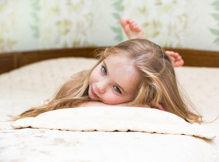 Little girl lying on the bed.の写真素材