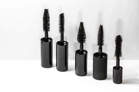 Set of mascara brushes standing in a row near the whaite wall, casting a shadow.の写真素材
