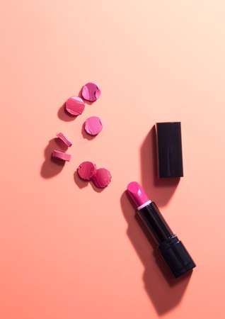 red sliced pieces near lipstick and capの写真素材