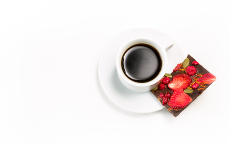 cup of coffee and hand-made chocolate with dried strawberries and berries on a white backgroundの写真素材