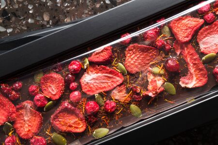 Handmade chocolate with dried strawberries, cranberry and pumpkin seedの写真素材