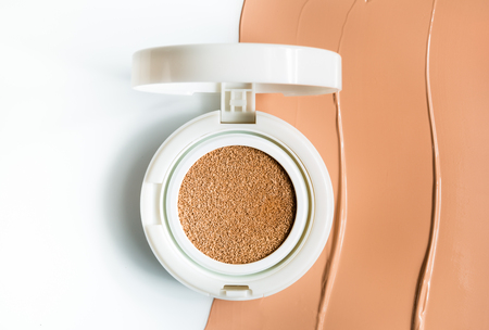 Foundation cushion on half of the surface of a tonal baseの写真素材