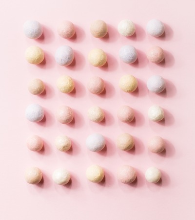 Pink blusher balls in a row on a pink background.の写真素材