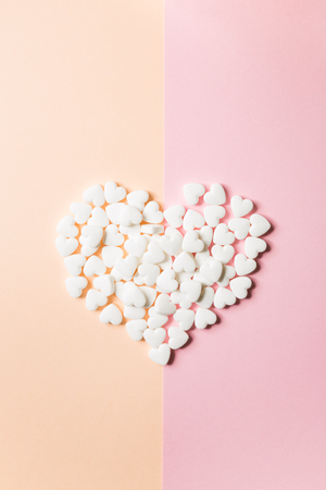 Tablets in the form of hearts on a double pink and solid background.の写真素材