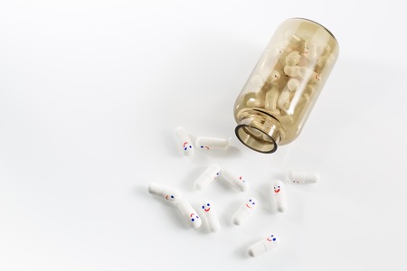 Glass bottle with fun painted emotions on the capsules. View from above.の写真素材
