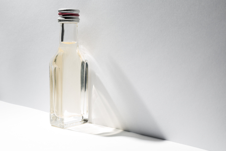 A bottle of vintage alcohol near the wall with oblique shadow.の写真素材