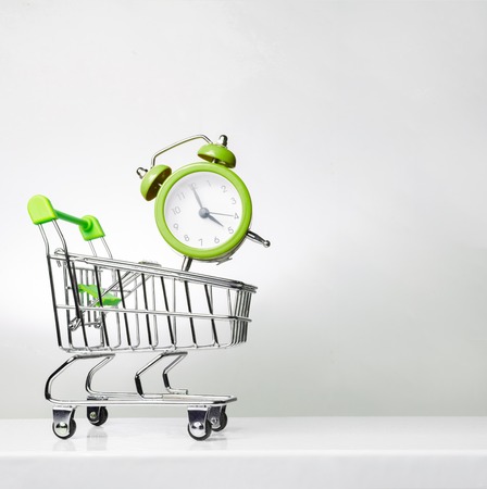 Alarm clock and shopping trolley with space for text. Time to shop.の写真素材