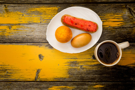 Coffee cup with pies top view on wooden with old yellow paintの写真素材