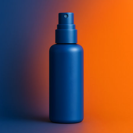 Detailed shot of atomizer with blue surface in front of split orange and darkblue color seamless background containerの素材