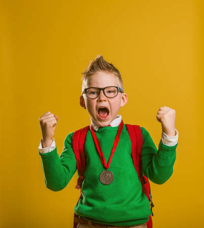 Happy boy raising trophy with hands up.の写真素材