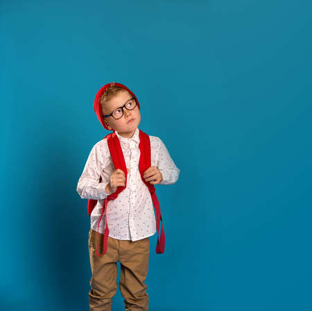 School boy choice. Child scratching head with question. concept for confusion, brainstorming and choiceの写真素材