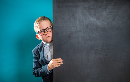 Happy smiling child with blackboard blank. Back to school concept. Little genius in glasses
