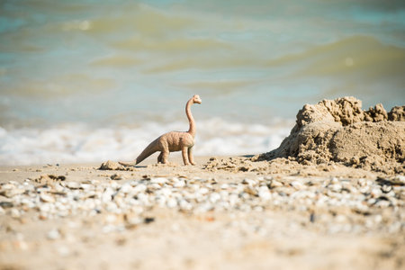 Dinosaurs model on the beach. toy dinosaur on the sand on the beach