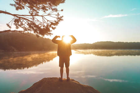 Young happy man spreading arms in morning nature. Strong and health conceptの写真素材