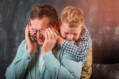 Dad and little kid boy spending time together at home. Man time to talk. portrait of little son hugging father in hospital chamber.の写真素材