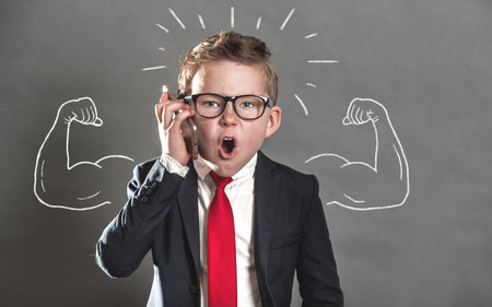 Angry little businessman with phone in hand shouting. Boss screaming because he is weak. Child with...