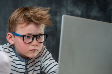 Online lesson for kids. Self isolation on lock down. Tablet for homework, Child using laptop...
