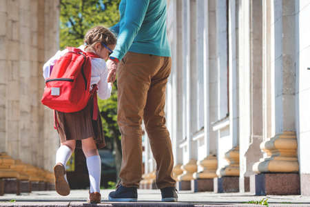 Girl does not want to study and go to school. Stress and angry girl. Dad hurries, is late to school and work. Child has tantrum before lessons. Parents, relationship with children and family problem.の写真素材