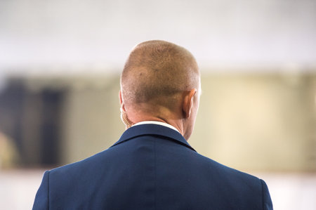 Protect guard or secret service agent listening to his earpiece on public meeting.の写真素材